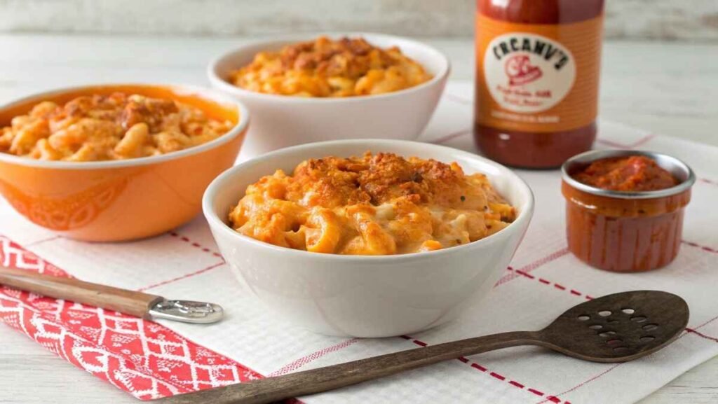 Three small bowls of buffalo chicken mac and cheese with varying levels of spiciness