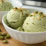 Ultra close-up shot of high-protein pistachio ice cream in a warm, consistent kitchen.
