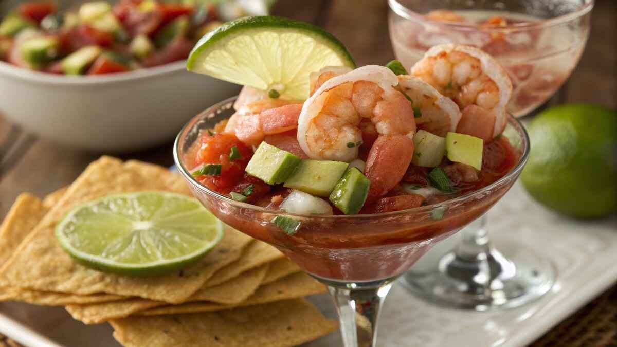 A close-up of a Mexican Shrimp Cocktail served in a glass with fresh ingredients.